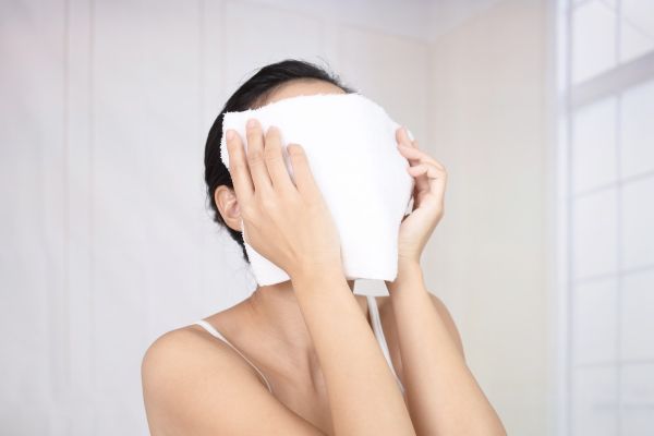 タオルで顔を覆う女性